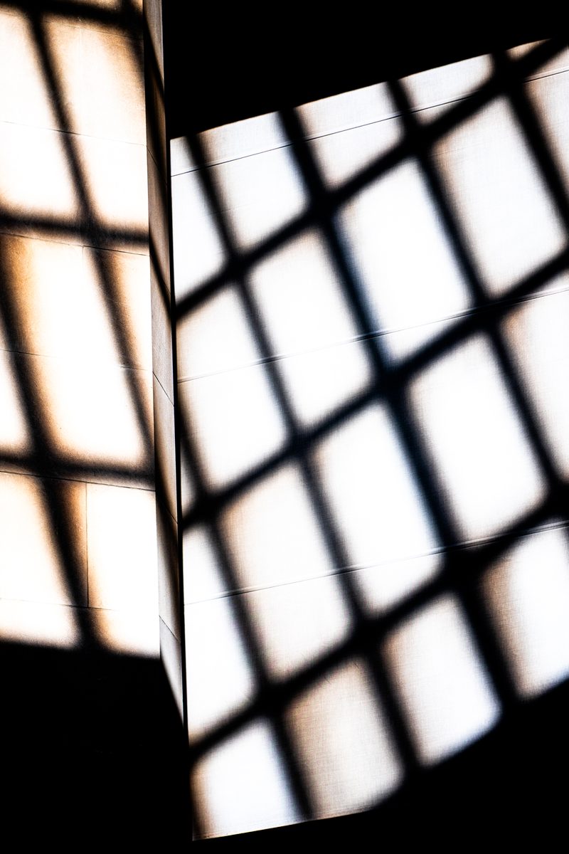 Grille de lumière — l'ombre d'une fenêtre sur le mur